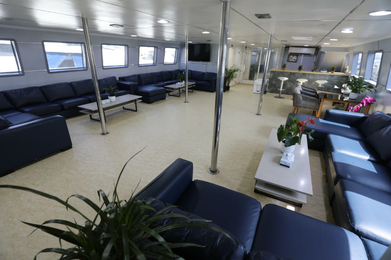 Spacious air-conditioned lounge on the 50 guest catamaran yacht with leather sofas and bar